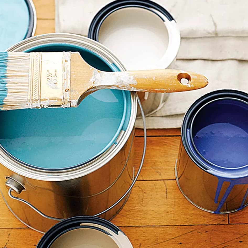 Several open paint cans and a paintbrush.