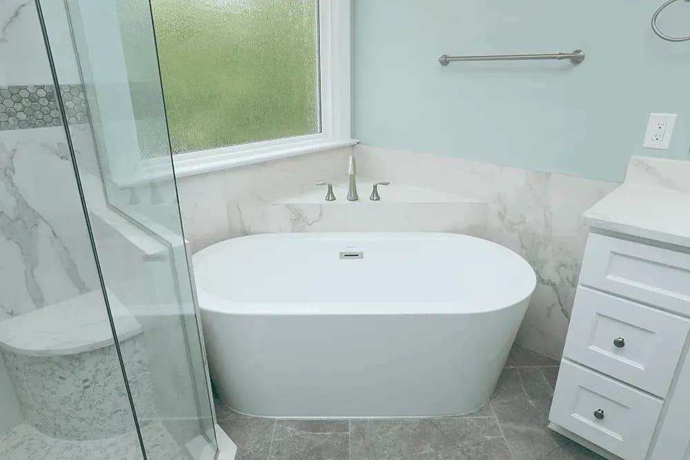 A white, oval, free-standing soaking bathtub.
